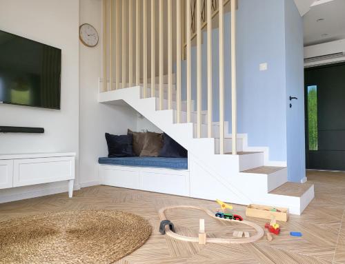 a living room with a staircase and a toy track at Błękitna Dębki in Dębki