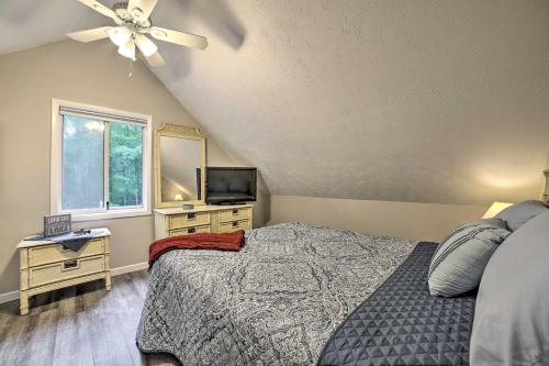 a bedroom with a bed and a television and a ceiling fan at Higgins Lake Getaway - Boating, Fish, Golf, ATV! in Roscommon