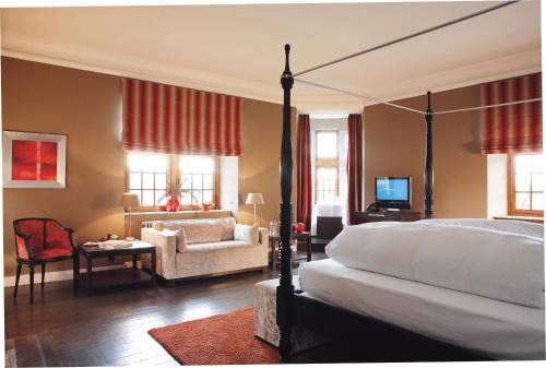 a bedroom with a bed and a chair and a couch at Manoir de Lébioles in Spa