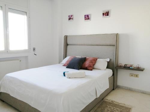 1 dormitorio con 1 cama con sábanas y almohadas blancas en My Second Home, en Túnez