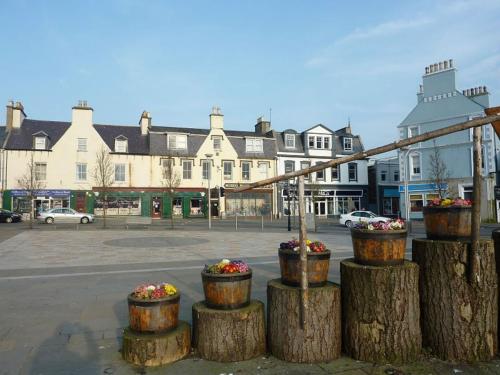 a group of flower pots sitting on tree logs at Taigh Geal in Stornoway