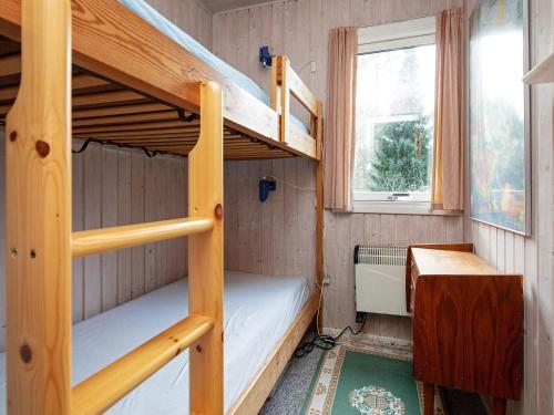 a bunk bed room with two bunk beds and a desk at Holiday home Sjællands Odde XI in Tjørneholm