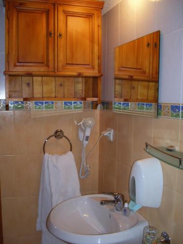 a bathroom with a sink and a phone on the wall at Rahoff hotel in Bansko