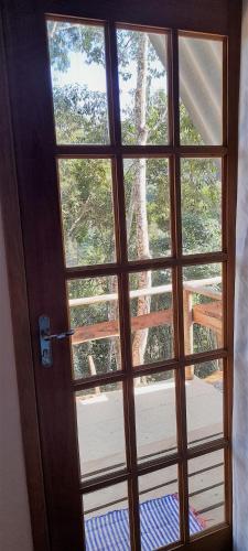 a door with a view of a tree outside at QuiCupimNunCria in Miguel Pereira