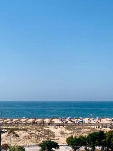 a beach with a lot of umbrellas and the ocean at Apartamento T1 Monte Gordo in Monte Gordo
