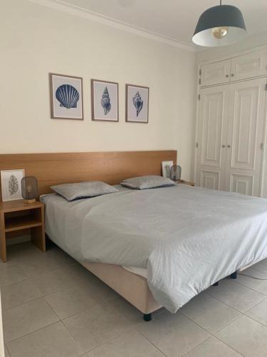 1 dormitorio con 1 cama grande y 2 almohadas en Apartamento T1 Monte Gordo, en Monte Gordo