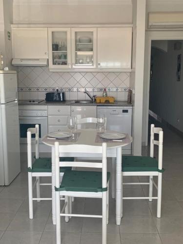 uma cozinha com uma mesa e cadeiras numa cozinha em Apartamento T1 Monte Gordo em Monte Gordo