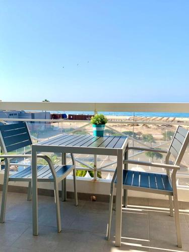 uma mesa e cadeiras com vista para a praia em Apartamento T1 Monte Gordo em Monte Gordo