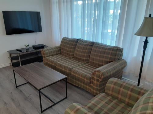 a living room with a couch and a coffee table at Le Pirate Motel et Camping in Cap-Chat