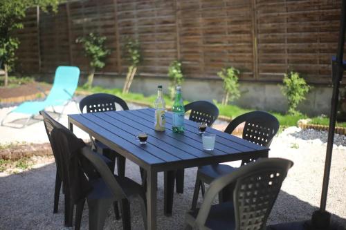 a blue table with chairs and bottles on it at La Montrieuse, Chambre individuelle avec sauna et baignoire spa in Naveil