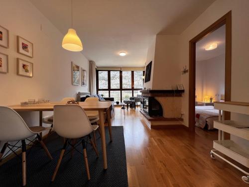 a living room with a dining room table and a bedroom at Escarra - Reformado, acogedor y luminoso, con garaje cubierto y ascensor BY PIRINEOS 360 in Escarrilla