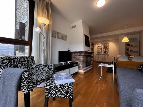 a living room with a couch and a fireplace at Escarra - Reformado, acogedor y luminoso, con garaje cubierto y ascensor BY PIRINEOS 360 in Escarrilla