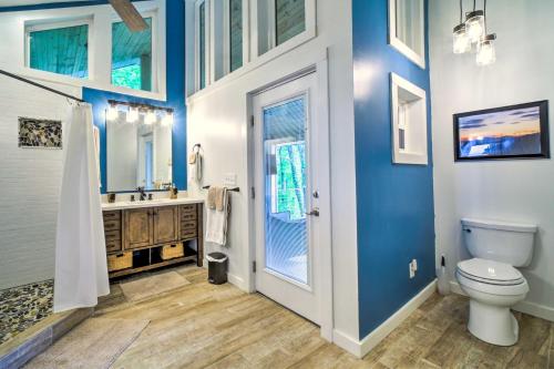 a bathroom with blue walls and a toilet and a sink at Mtn Treehouse with Fire Pit, Breathtaking Views in Waynesville