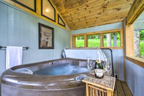 a tub with a bottle of wine and two glasses at Mtn Treehouse with Fire Pit, Breathtaking Views in Waynesville
