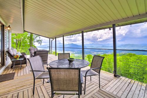 a screened in porch with a table and chairs at Mtn Treehouse with Fire Pit, Breathtaking Views in Waynesville