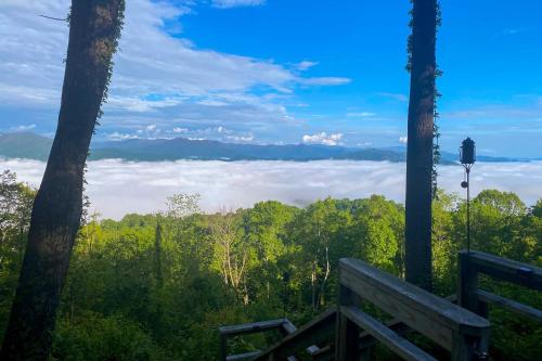 a bench with a view of trees and clouds at Mtn Treehouse with Fire Pit, Breathtaking Views in Waynesville