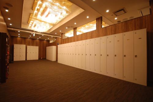 ein großes Zimmer mit weißen Schließfächern in einem Gebäude in der Unterkunft Kokusai Hotel Yamaguchi in Yamaguchi