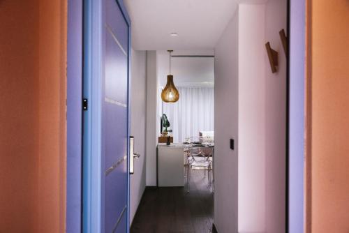 pasillo con puerta morada y comedor en Suites De Luxe Katerina, en Kokkinos Pirgos