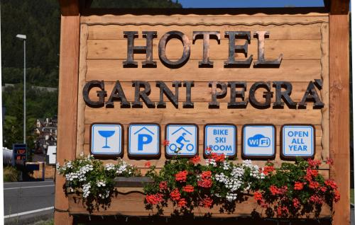 a sign for a hotel grand peoria with signs on it at Hotel Garni Pegrà in Ponte di Legno