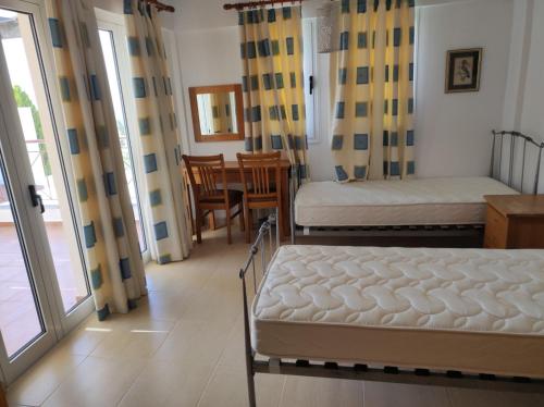 a bedroom with two beds and a table and chairs at VILLA SERAPHO in Paphos
