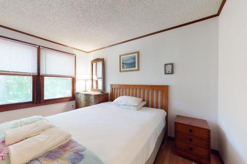 - une chambre avec un lit blanc et 2 fenêtres dans l'établissement Sea Glen Cottage, à Oak Bluffs
