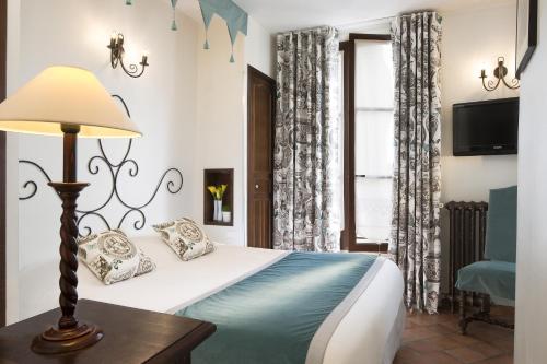 a hotel room with a large bed and a large window at Castex Hotel in Paris