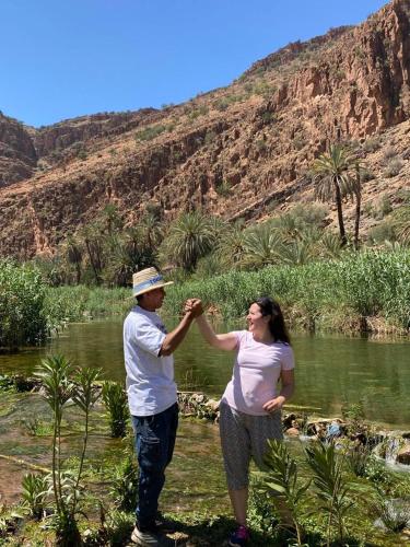 a man and a woman standing next to a river at Oasis de Tiout in Tiout