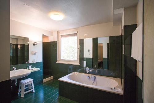 un ampio bagno con vasca e lavandino di Hotel Buonconsiglio a Trento