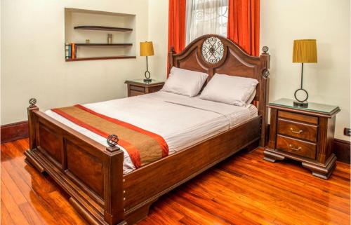 サンホセにあるAmon Mansiónのベッドルーム1室(大型木製ベッド1台、ナイトスタンド2台付)