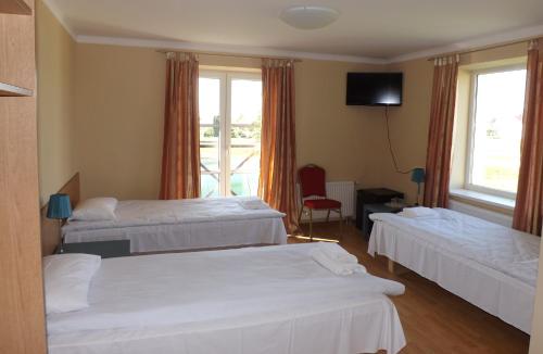 a hotel room with two beds and a television at Kaimo turizmas "Svečių namai Moteliukas" in Alytus