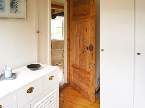uma cozinha com um armário branco e uma porta em Holiday home FLEN III em Flen