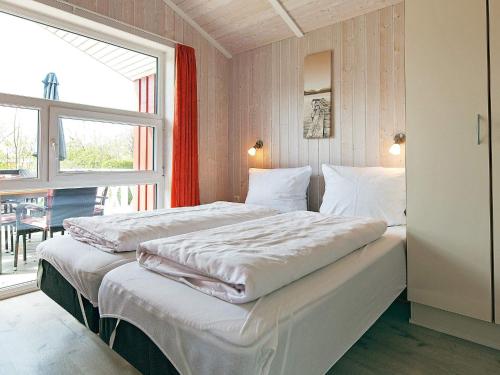two beds in a room with a window at Three-Bedroom Holiday home in Grömitz 7 in Grömitz