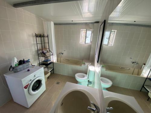 a bathroom with a toilet and a washing machine at My Olive Tree House in Kalamata