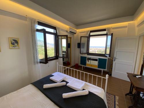 a bedroom with a bed with two towels on it at My Olive Tree House in Kalamata