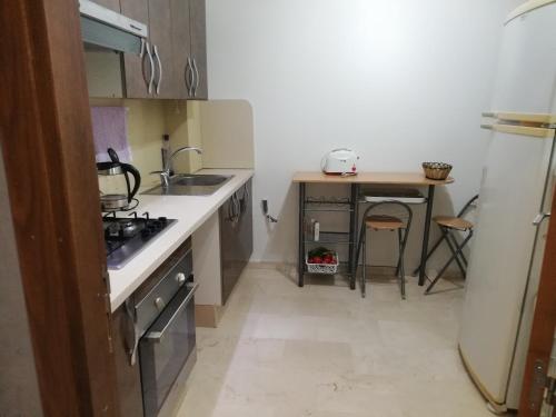 une petite cuisine avec un évier et une table dans l'établissement Appartement Résidence fermée, à Casablanca