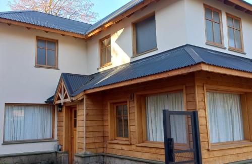 a house with a solar roof on top of it at Refugio del Arroyo in San Martín de los Andes