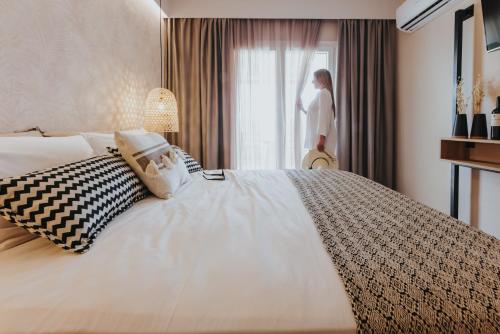 a woman looking out the window of a hotel room at Villa veranda in Plaka