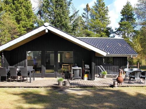 a black house with a patio and a grill at 6 person holiday home in N rre Nebel in Nørre Nebel