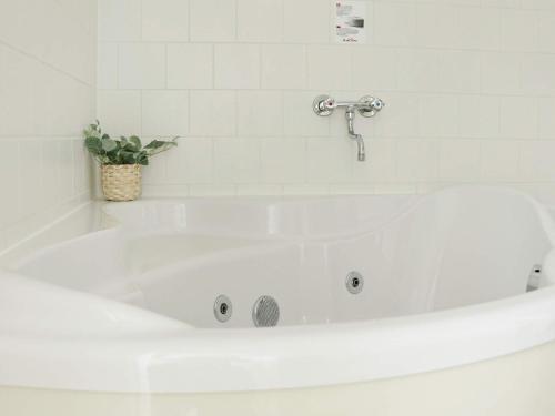 a white bath tub with a plant in a bathroom at 8 person holiday home in Gjern-By Traum in Gjern