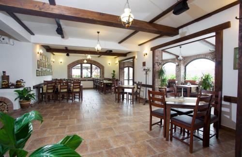 un comedor con mesas y sillas en un restaurante en Pensiunea Laci Csarda Ernei, en Ernei