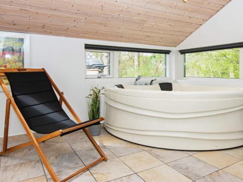 eine Badewanne in einem Zimmer mit einem Stuhl und einem Stuhl in der Unterkunft 8 person holiday home in Ebeltoft in Øksenmølle