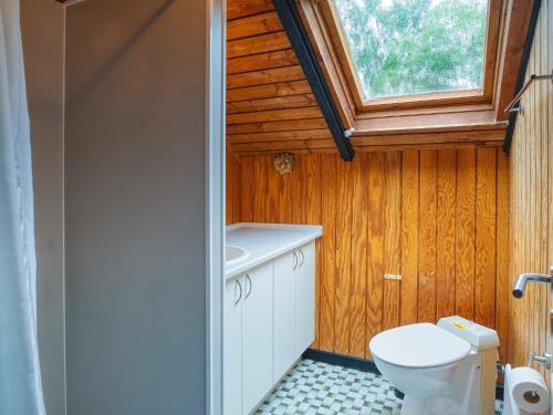 a small bathroom with a toilet and a window at Three-Bedroom Holiday home in Rødby 28 in Kramnitse