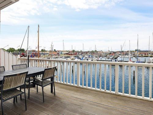 un balcone con tavolo, sedie e un porto turistico. di 8 person holiday home in Bagenkop a Bagenkop
