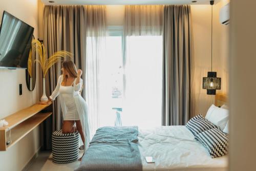 a woman is standing in a bedroom looking out the window at Villa veranda in Plaka