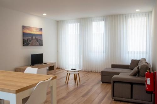 a living room with a couch and a table at Ria Sal apartments in Aveiro