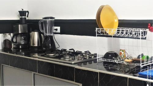 a kitchen counter with a stove and a sink at Casa de Luz in Cali