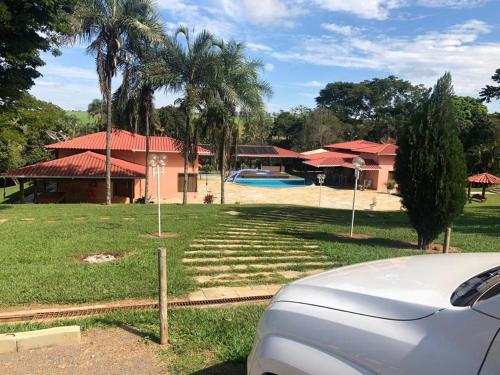 a car parked in front of a house with a pool at Chácara de Luxo em Anápolis in Anápolis