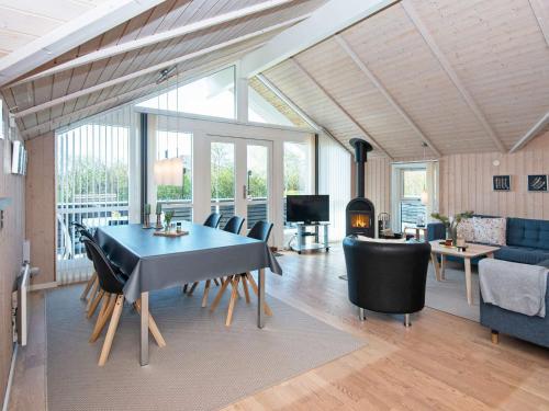 a living room with a table and chairs and a couch at 6 person holiday home in Hemmet in Falen
