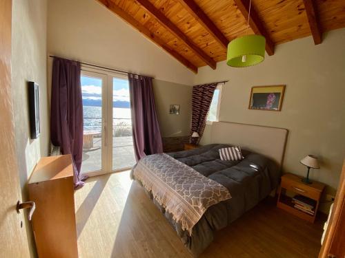 a bedroom with a bed and a large window at Lake in San Carlos de Bariloche