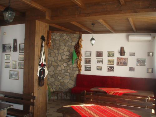 a living room with a red couch and a stone wall at Mania Guest House in Kalofer